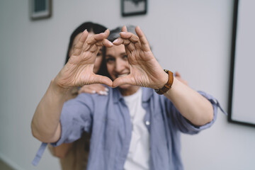 Mother and daughter showing heart gesture