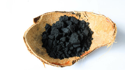 pile of charcoal with green leaf decoration on white isolated background