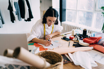 Female designer artist creating sketches of clothes