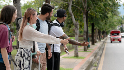 Foreign tourists hitchhike in Chiang Mai in Thailand.