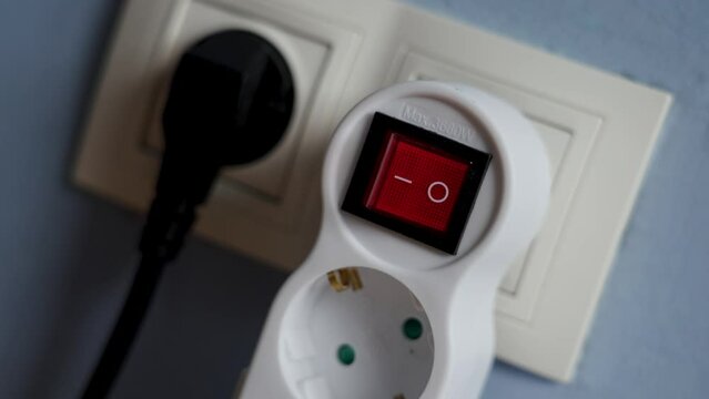Switching off the electricity supply by pressing the red button of a home electrical splitter closeup