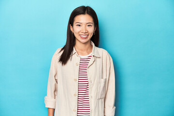 Asian woman in layered shirt and striped t-shirt, happy, smiling and cheerful.