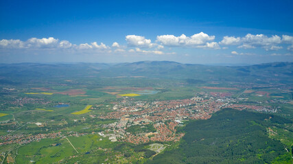 Panoramic shot on the city in the mountains in early spring. Top view from a drone