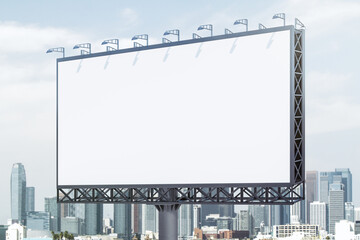 Fototapeta premium Blank white billboard on city buildings background at daytime, perspective view. Mockup, advertising concept