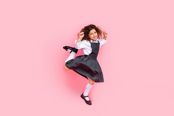 Full length portrait of energetic active schoolchild jumping raise fists success isolated on pink...
