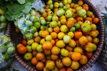 A Pile of fresh tomatoes with various colors on display at the local farmer's market on a sunny morning. Freshly Harvested tomatoes background.