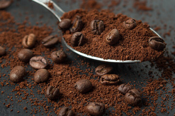 Coffee beans and ground coffee on a black background