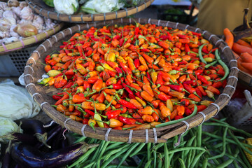 Piles of fresh hot peppers on display at the local farmers market. Freshly harvested hot pepper background.