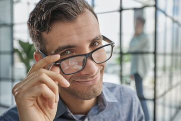 IT guy adjusting glasses in a modern new office