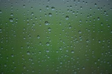 Fototapeta na wymiar Lots of raindrops on the window. Rainy season concept. Climate change. Wet in rain. Focus on water droplets on window.