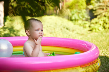 cute baby girl swimming in kid inflatable pool