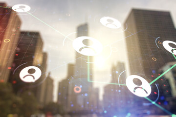 Double exposure of abstract virtual social network icons on modern skyscrapers background....