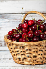 Fototapeta na wymiar Fresh cherry in a wicker basket over wooden background. Cherry harvest season concept. Healthy and fresh fruit. Close up