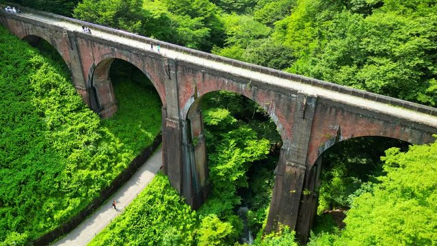森の中を通る古い鉄橋、めがね橋の空撮｜An old iron bridge passing through the forest. Aerial view of Meganebashi Bridge