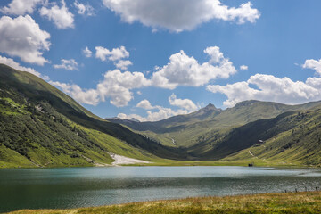 Naklejka na ściany i meble Alpine Lake with Hilly Landscape in Austria. Tappenkarsee with Green European Scenery and Blue Sky with Clouds.