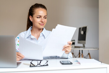 Brunette woman working with financial documents, businesswoman in office.