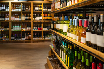 Background wine bottles in a row on shelves in wine boutique.