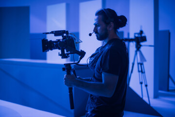 Director of photography with a camera in his hands on the set. Professional videographer at work on...