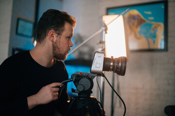 Director of photography with a camera in his hands on the set. Professional videographer at work on filming a movie, commercial or TV series.