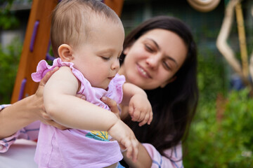 Fototapeta na wymiar little baby girl with mother on slide in playground