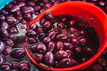 Close up view of olives in a basket with salt water.