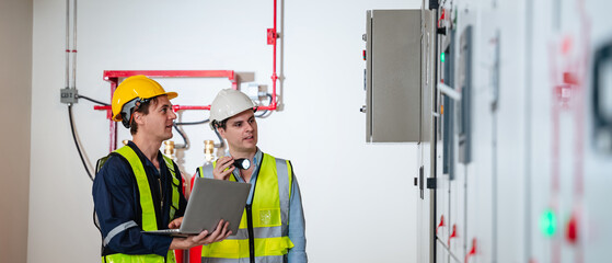 The engineers inspected the electrical switchboard and verified the operational voltage range in control room of factory.