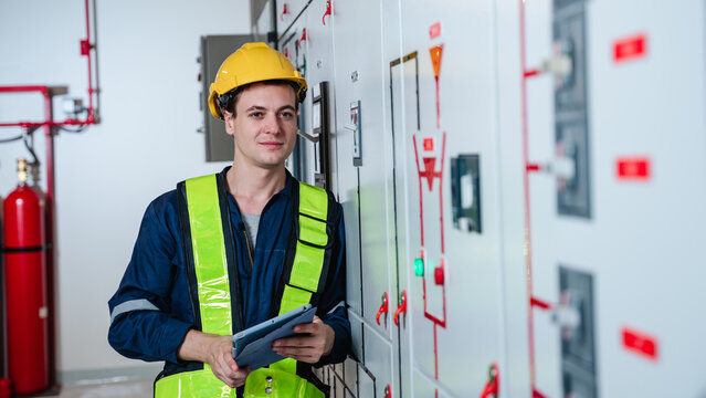 The engineers inspected the electrical switchboard and verified the operational voltage range in control room of factory.