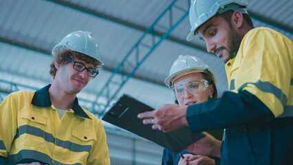 Professional, Team industrial engineer colleague or technician worker wearing safety uniform, hard hat using tablet discuss automated robotic arm machine in factory. Automatic Industry concept.