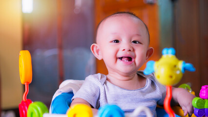Fototapeta na wymiar Close-up portrait of face cute Asian newborn baby boy with happy smile and funny laughing