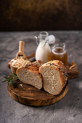 Artisan bread whole wheat baguette white milk and honey on rustic wooden board and abstract table....