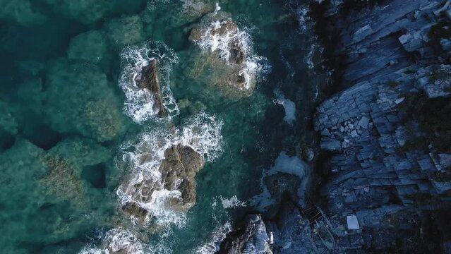  Drone 4k top down view of a beach shore with rocks and waves seamless loop