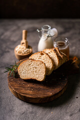 Artisan bread whole wheat baguette white milk and honey on rustic wooden board and abstract table....