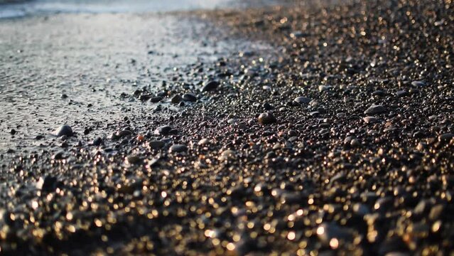 Waves in sea on sunrise. Pebble stone beach on sunset. Sea beach shore with waves in ocean. Empty coastline pebble beach. Sea beach landscape. Shore landscape. Ocean shoreline scenic.