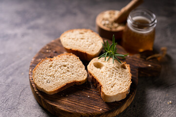 Artisan bread whole wheat baguette white milk and honey on rustic wooden board and abstract table. Sourdough bread
