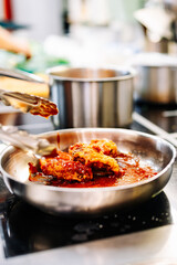 cooking chicken wings in a sauce in the kitchen