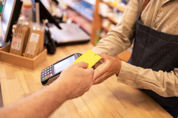 Crop man paying with credit card in drugstore