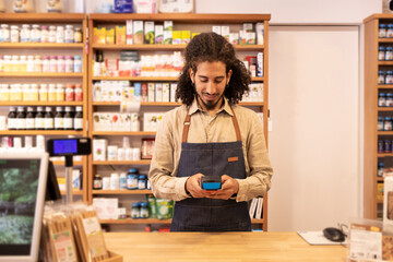Ethnic man using point of sale machine in shop