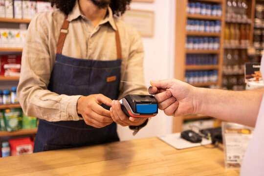 Crop man paying with credit card in drugstore