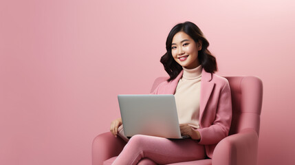 Naklejka premium Young Asian girl sits in a chair and works on her laptop.