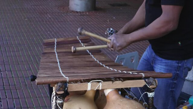 Xylophone play in slow motion, percussion instrument concept - street performer play onb wooden bars with mallets in hands