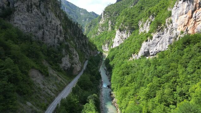 The drone flies over a huge, deep canyon, flanked by green mountains and rocks. Canyon of the Tara River. Montenegro. Aerial view.