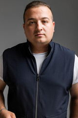 A cheerful young man model in a sleeveless regular solid jacket and a black sunglass posing in multiple different styles over white background with dimensions of width 5464 p and height 8192 p
