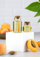 Apricot oil and fresh apricots in a transparent bottle. Natural cosmetic. Copy space.