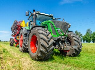 Large modern agricultural tractor with attached corn planter, food and energy crisis, parked sunlight farmers in the countryside.