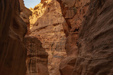 Canyon Siq or El Siq in Petra Jordan. Only road to rock city of Nabatean kingdom, to ancient city of Petra. Huge rocks hang over a narrow path, 92 to 182 meters high