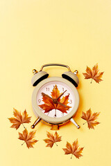 retro alarm clock with autumn leaves and copy space like romantic autumn time concept 