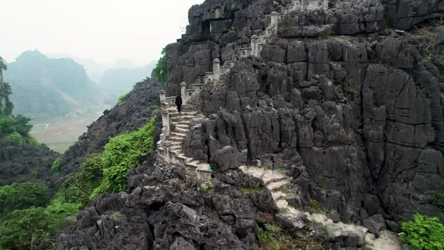 Vue a&eacute;rienne de Hang Mua &agrave; Ninh Binh au Vietnam, paysage karstique avec grotte, escalier et pagode sur la montagne du dragon couch&eacute;, culture et nature dans la baie d&rsquo;Halong terrestre.