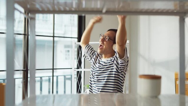 greeting happiness joyful asian adult male wearing casual cloth and wirreless headphone dance music lover while unpack stuff relax from home moving house relocation ,he is happy to move in new house