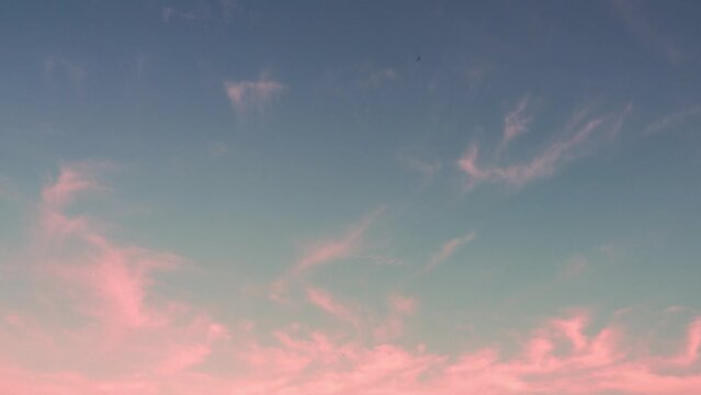 abstract pastel blue sky. wispy pink clouds moving low in the air. Timelapse footage clouds in clear space autumn or fall chilly weather. season change nature color change. moment of moving forward