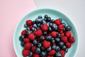 Plate with delicious raspberry strawberries and blueberries on a light background. Fresh organic berries and fruits. Farm ecological product. Without GMO. Fresh vitamins 
